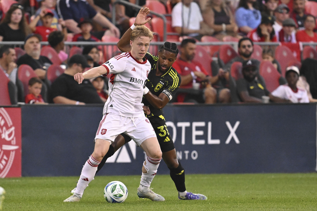 Toronto FC's Ola Brynhildsen, front, defends the ball against Columbus Crew's Steven Moreira during first-half MLS soccer action in Toronto, Saturday, Aug. 16, 2025. (Jon Blacker/The Canadian Press via AP)