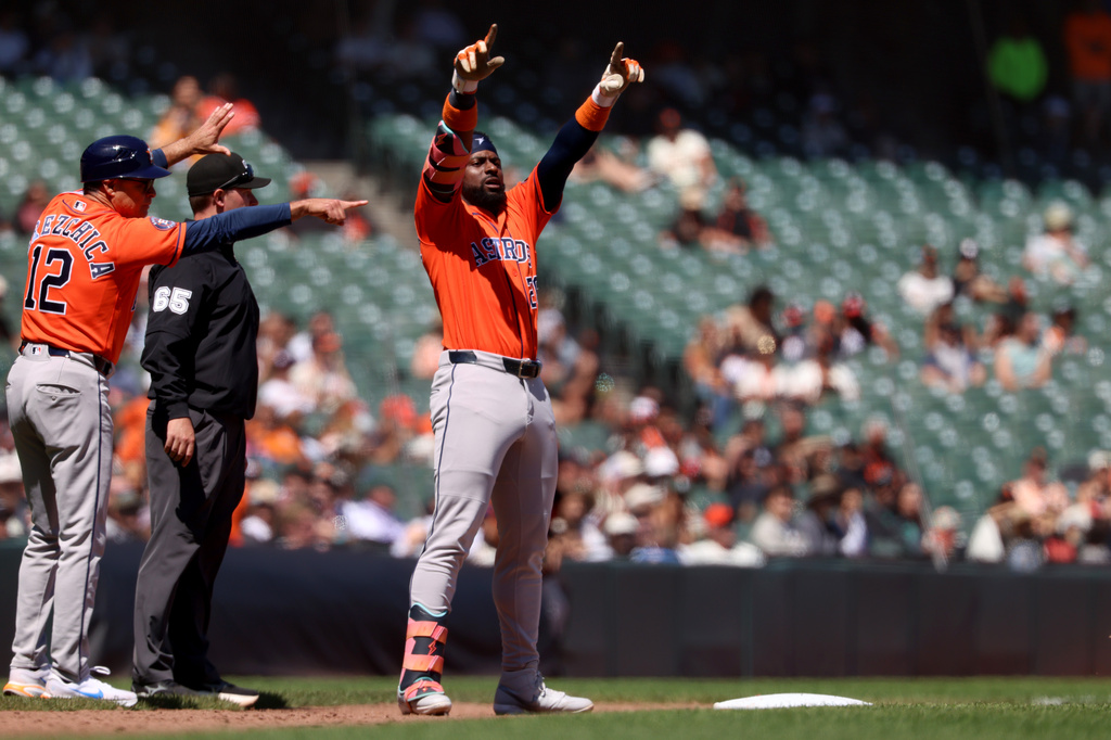 Houston Astros' Taylor Trammell (26) gestures to teammates after hitting a triple during the eighth inning of a baseball game against the San Francisco Giants in San Francisco, Wednesday, Aug. 12, 2026. (AP Photo/Jed Jacobsohn)