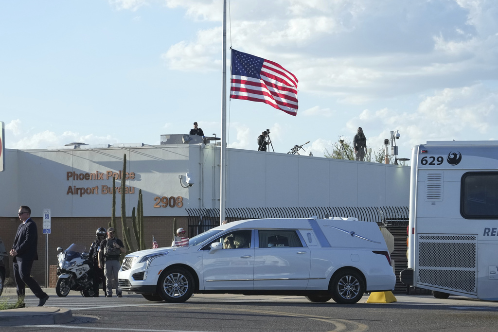 A hearse containing the body of Charlie Kirk, the CEO and co-founder of Turning Point USA who was shot and killed on Wednesday leaves after being removed from Air Force Two at Phoenix Sky Harbor International Airport, Thursday, Sept. 11, 2025, in Phoenix. (AP Photo/Ross D. Franklin)
