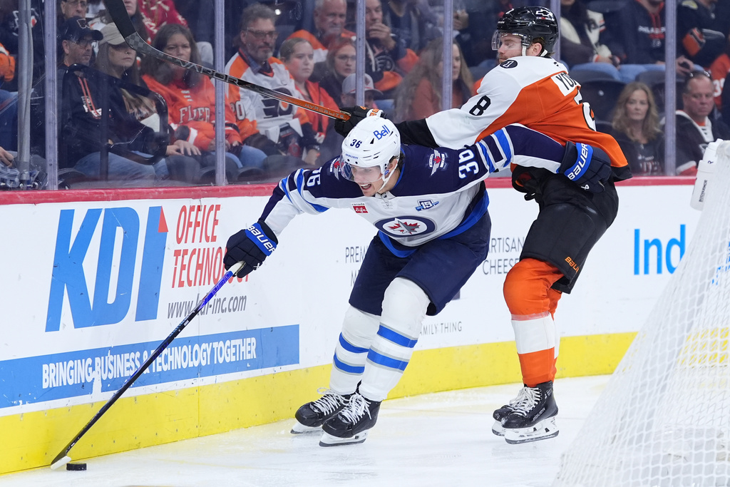 Winnipeg Jets' Morgan Barron, left, tries to get past Philadelphia Flyers' Cam York during the third period of an NHL hockey game, Thursday, Oct. 16, 2025, in Philadelphia. (AP Photo/Matt Slocum)
