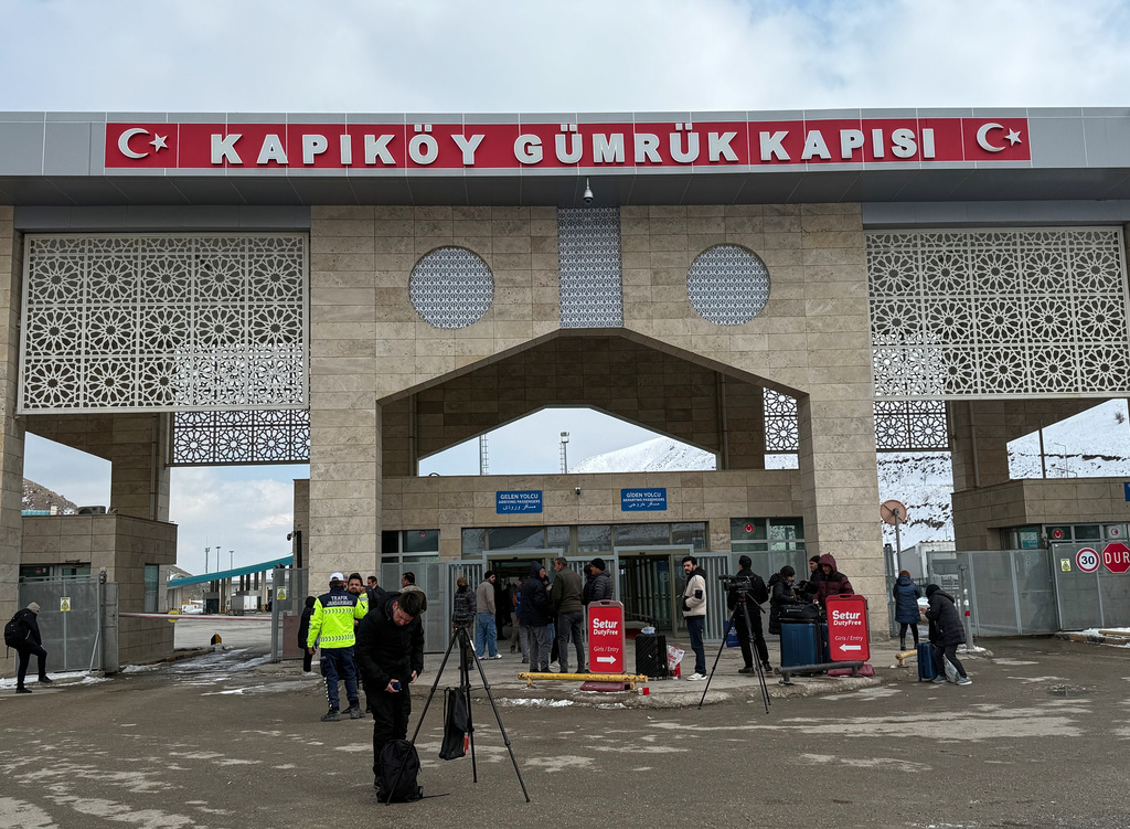 People, mostly Iranians, wait after crossing from Iran at the Kapikoy border crossing in eastern Van province, Turkey, Thursday, March 5, 2026. (AP Photo/Serra Yedikardes)