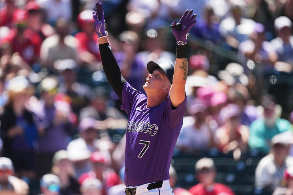Colorado Rockies' TJ Rumfield gestures as he crosses home plate after hitting a two-run home run off Cincinnati Reds relief pitcher Caleb Ferguson in the sixth inning of a baseball game Saturday, July 18, 2026, in Denver. (AP Photo/David Zalubowski)