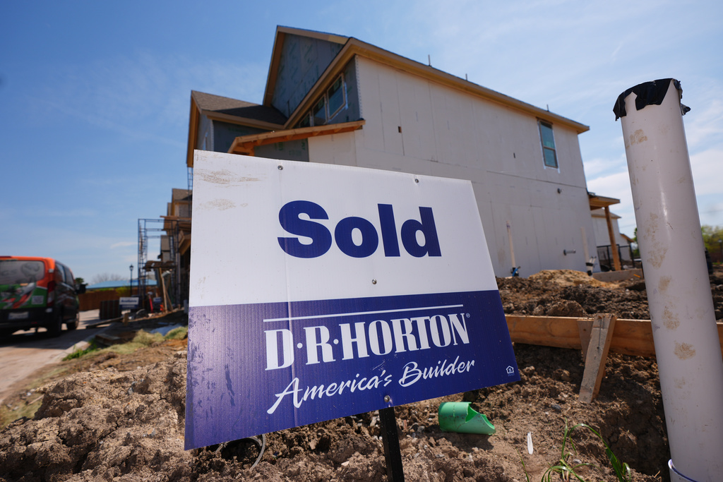 A sold sign sits on a lot for a home built by DR Horton in Richardson, Texas, Monday, March 23, 2026. (AP Photo/LM Otero)