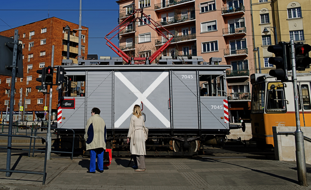 Commuters look at a century-old freight tram in Budapest, Hungary on Thursday, March 12, 2026. (AP Photo/Bela Szandelszky)