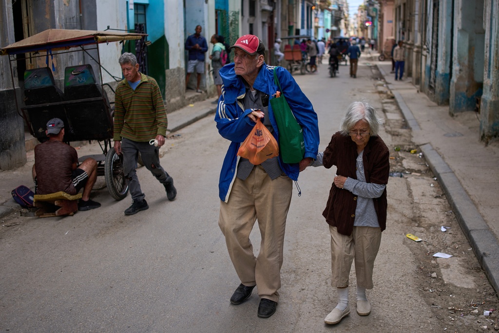 People walk down a street in Havana, Tuesday, Feb. 24, 2026. (AP Photo/Ramon Espinosa)