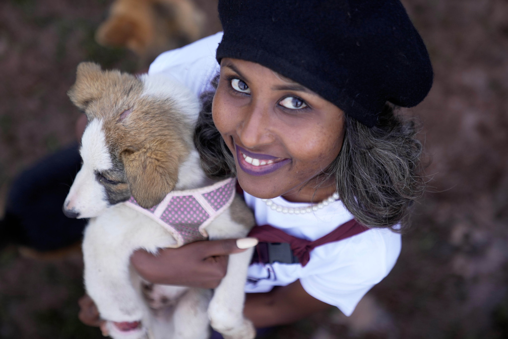 Feven Melesein, 29-years-old, holds a dog that was abandoned on the streets of the capital, Addis Ababa, Ethiopia, Sunday, Sept. 7, 2025. (AP Photo/Brian Inganga)