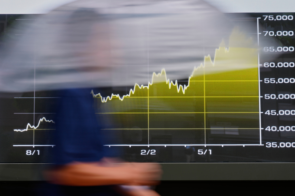A person walks in front of an electronic stock board showing Japan's Nikkei index at a securities firm Tuesday, July 28, 2026, in Tokyo. (AP Photo/Eugene Hoshiko)