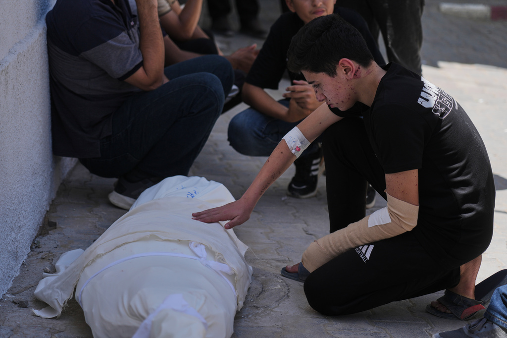 Omar Klaub, injured in an Israeli strike, mourns beside the body of his mother, Rana, who was killed in the same attack, during her funeral at Shifa Hospital in Gaza City, Thursday, June 4, 2026. (AP Photo/Jehad Alshrafi)