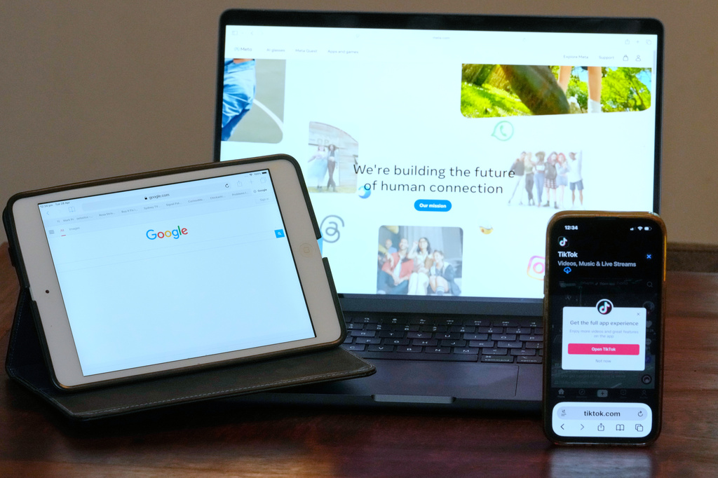 The home pages of Meta, Google and TikTok are displayed on devices in Sydney, Tuesday, April 28, 2026. (AP Photo/Rick Rycroft)