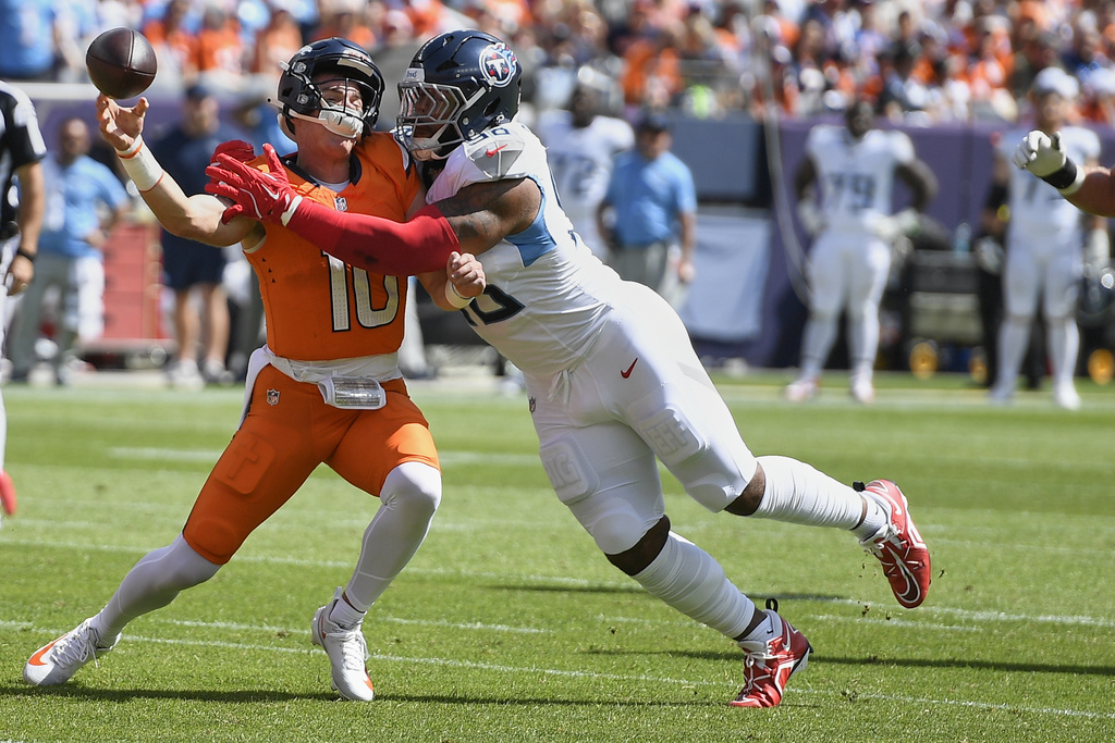 Tennessee Titans defensive tackle Jeffery Simmons, right, pressures Denver Broncos quarterback Bo Nix (10) during the first half of an NFL football game Sunday, Sept. 7, 2025, in Denver. (AP Photo/Eric Lutzen)