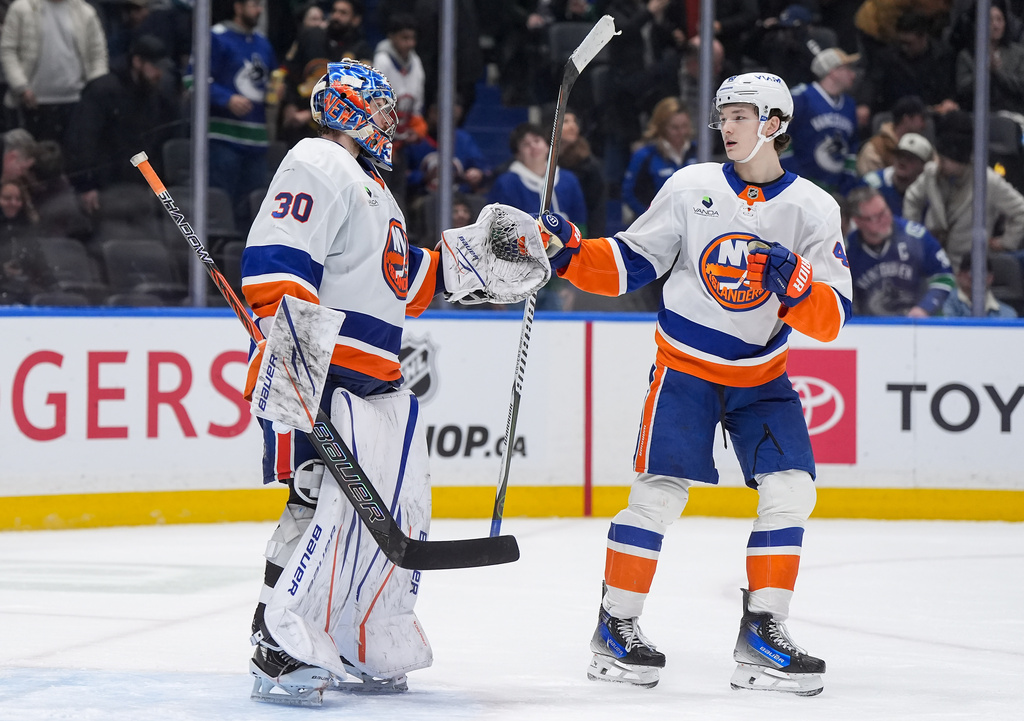 New York Islanders goalie Ilya Sorokin, left, and Matthew Schaefer celebrate after New York defeated the Vancouver Canucks 4-3 during an NHL hockey game in Vancouver, B.C., Monday, Jan. 19, 2026. (Darryl Dyck/The Canadian Press via AP)
