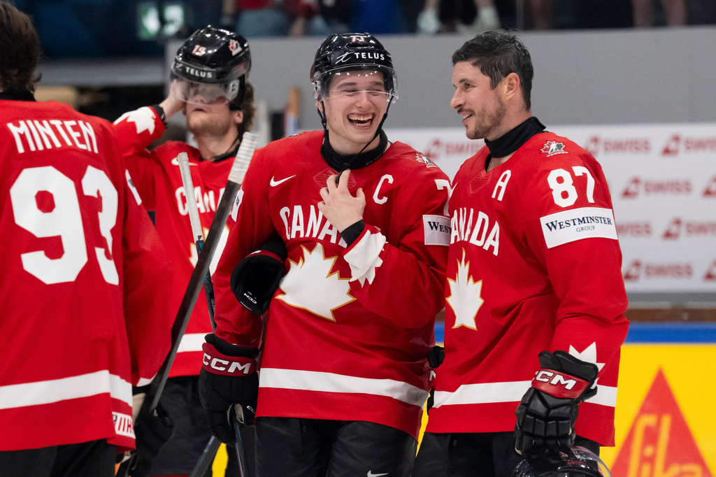 Canada's Macklin Celebrini. second from right, and Sidney Crosby, right, celebrate after winning the the Group B preliminary round between the Czech Republic and Canada at the men's ice hockey world championship in Fribourg, Switzerland, Tuesday, May 26, 2026. (Anthony Anex/Keystone via AP)