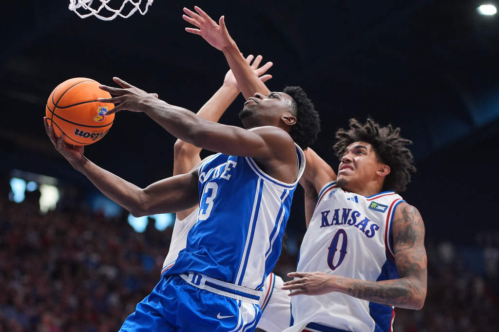 Duke's John Blackwell (13) gets past Kansas' Taylen Kinney (0) to put up a shot during the second half of an exhibition NCAA college basketball game Sunday, Oct. 25, 2026, in Lawrence, Kan. (AP Photo/Charlie Riedel)