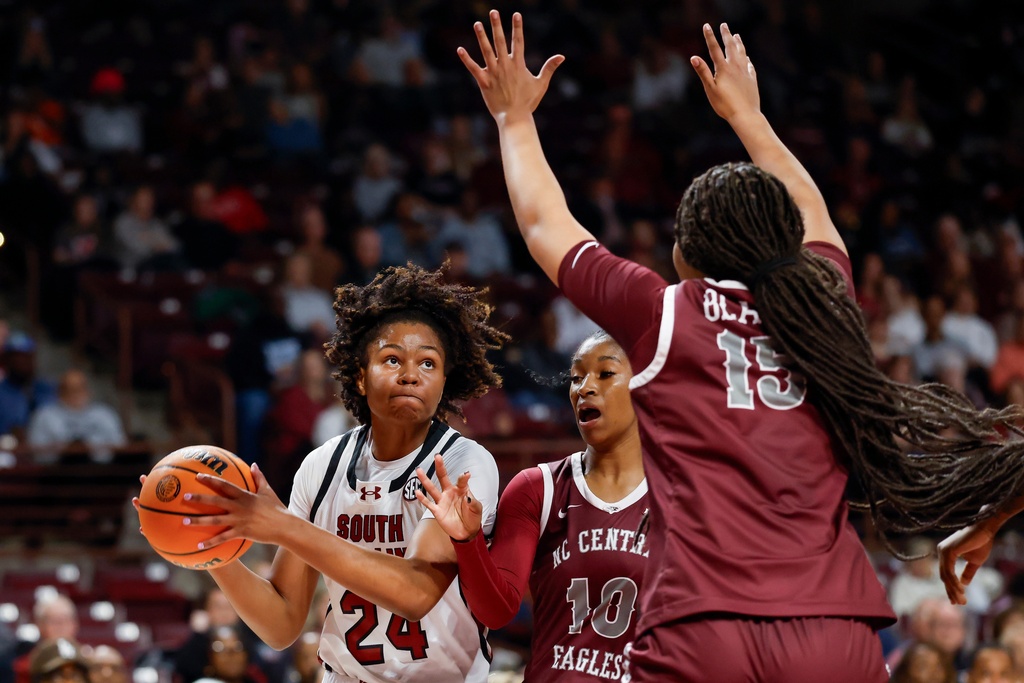 South Carolina guard Ayla McDowell (24) looks to shoot against North Carolina Central guard Shakiria Foster (10) and forward Dianna Blake during the first half of an NCAA college basketball game in Columbia, S.C., Sunday, Dec. 7, 2025. (AP Photo/Nell Redmond)
