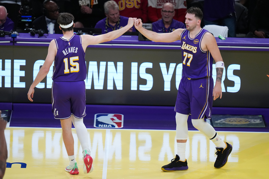 Los Angeles Lakers guard Luka Doncic (77) celebrates his basket with guard Austin Reaves (15) during the first half of an NBA Cup basketball game against the Los Angeles Clippers Tuesday, Nov. 25, 2025, in Los Angeles. (AP Photo/Jae C. Hong)