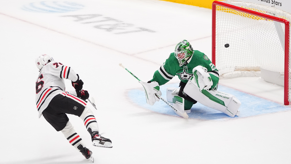 Chicago Blackhawks left wing Nick Lardis (76) scores a goal against Dallas Stars goaltender Jake Oettinger (29) during a shootout after regulation play of an NHL hockey game Saturday, Dec. 27, 2025, in Dallas. (AP Photo/LM Otero)