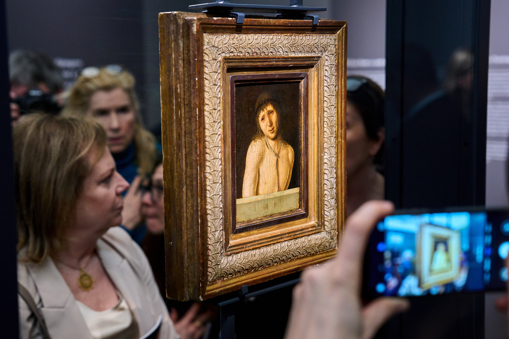 Journalists look at Antonello da Messina's Ecce Homo, a tempera-on-panel painting dating from around 1470 and measuring 20.3 by 14.9 centimeters, recently acquired by the Italian General Directorate of Museums for $14.9 million, or about 12.6 million euros in Rome, Thursday, March 26, 2026 . (AP Photo/Domenico Stinellis)