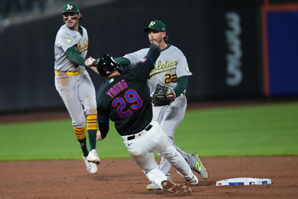 Athletics' Jeff McNeil (22) throws out New York Mets' Luis Robert Jr. at first base after forcing out New York Mets' Jared Young (29) for a double play during the sixth inning of a baseball game Friday, April 10, 2026, in New York. (AP Photo/Frank Franklin II)