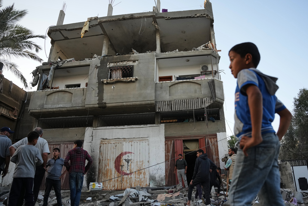 Palestinians inspect the damage to a house targeted by an Israeli strike in Deir al-Balah, in the central Gaza Strip, Saturday, Nov. 22, 2025. (AP Photo/Abdel Kareem Hana)