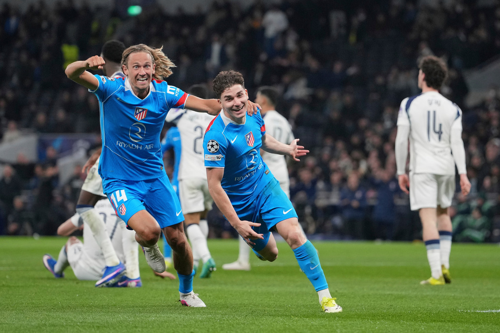 Atletico Madrid's Julian Alvarez, centre, celebrates with Atletico Madrid's Marcos Llorente after scoring his side's first goal during the Champions League round of 16, second leg soccer match between Tottenham and Atletico Madrid in London, England, Wednesday, March 18, 2026. (AP Photo/Kin Cheung)