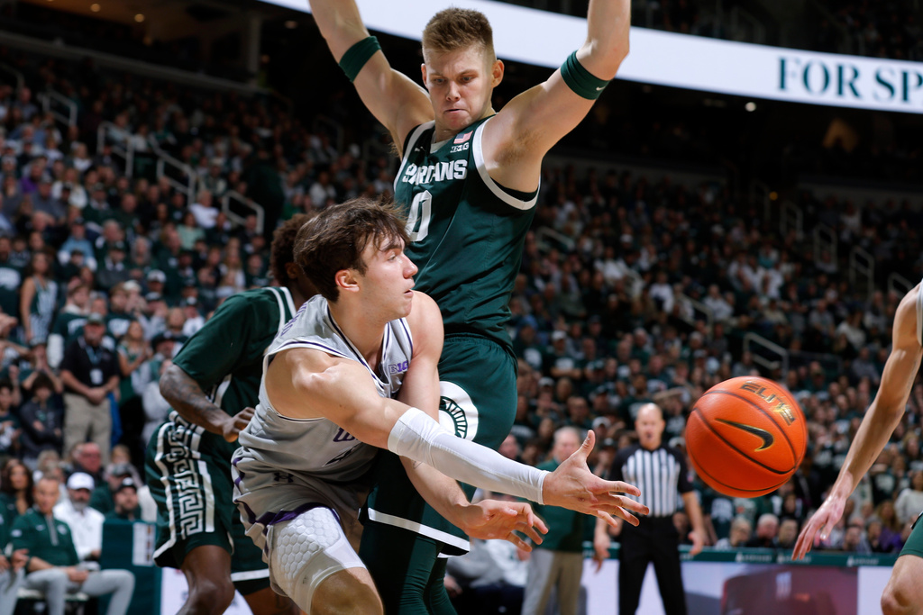 Northwestern guard Angelo Ciaravino, bottom front, passes the ball against pressure from Michigan State forward Jaxon Kohler (0) during the first half of an NCAA college basketball game, Thursday, Jan. 8, 2026, in East Lansing, Mich. (AP Photo/Al Goldis)