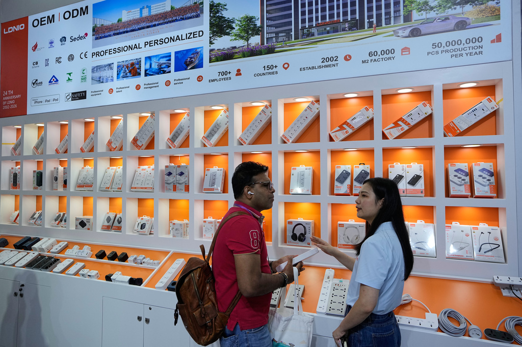 A vendor attends a foreign visitor at a booth showcasing electronic devices at the Canton Fair, in Guangzhou, in southern China's Guangdong province, Wednesday, April 15, 2026. (AP Photo/Andy Wong)