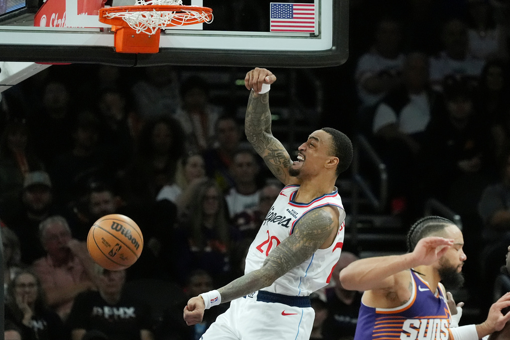 Los Angeles Clippers forward John Collins (20) dunks against Phoenix Suns forward Dillon Brooks, right, during the first half of an NBA basketball game Sunday, Feb. 1, 2026, in Phoenix. (AP Photo/Ross D. Franklin)