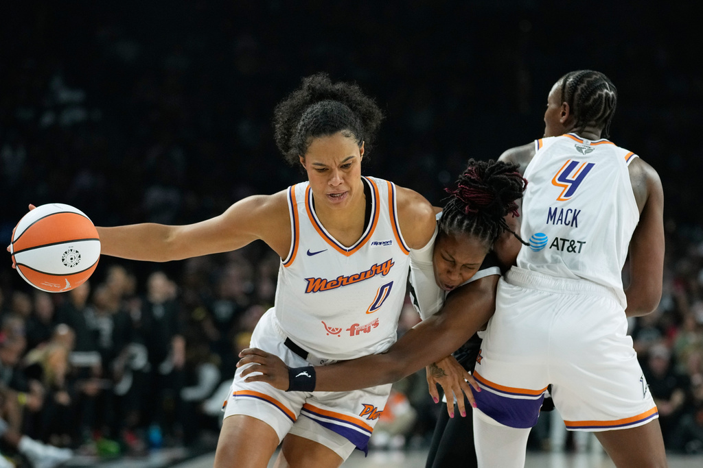 Phoenix Mercury forward Satou Sabally (0) works toward the basket as Las Vegas Aces guard Chelsea Gray (12), center, defends during the first half in Game 2 of the WNBA basketball finals, Sunday, Oct. 5, 2025, in Las Vegas. (AP Photo/John Locher)