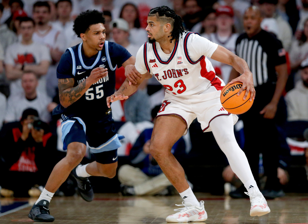 Villanova guard Acaden Lewis, left, defends St. John's forward Bryce Hopkins during the first half of an NCAA college basketball game Saturday, Feb. 28, 2026, in New York. (AP Photo/John Munson)