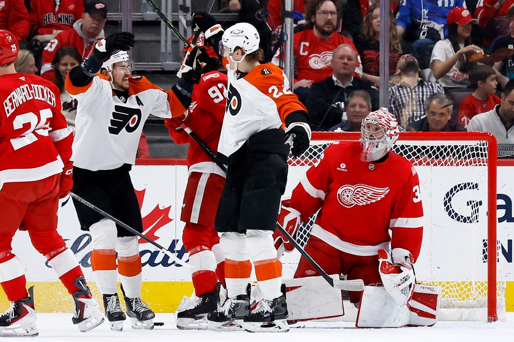 Philadelphia Flyers center Christian Dvorak (22) celebrates with right wing Travis Konecny, second from left, after scoring against Detroit Red Wings goaltender John Gibson, right, during the first period of an NHL hockey game Thursday, April 9, 2026, in Detroit. (AP Photo/Duane Burleson)