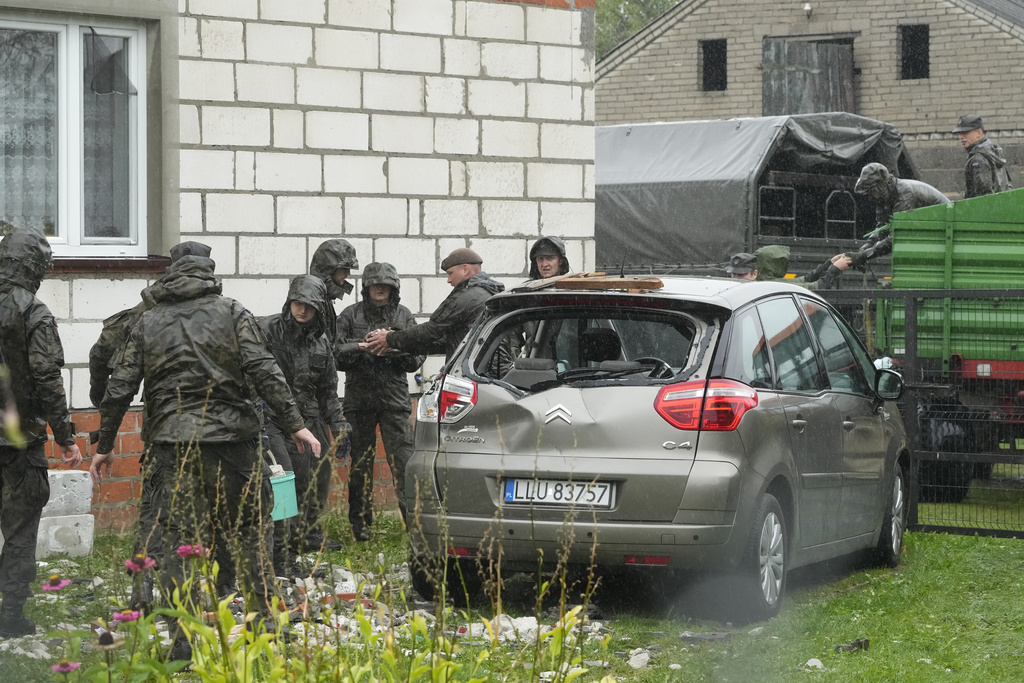 Territorial defense officers clean up debris from the destroyed roof of a house, after Russian drones violated Polish airspace during an attack on Ukraine, in Wyryki near Lublin, Poland, Thursday, Sept. 11, 2025. (AP Photo/Czarek Sokolowski)