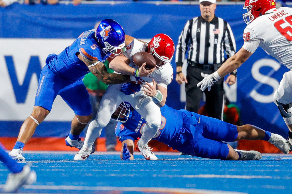 Boise State defensive end Jayden Virgin-Morgan (5) knocks the ball loose from New Mexico quarterback Jack Layne (2) for a fumble in the first half of an NCAA college football game, Saturday, Oct. 11, 2025, in Boise, Idaho. (AP Photo/Steve Conner)