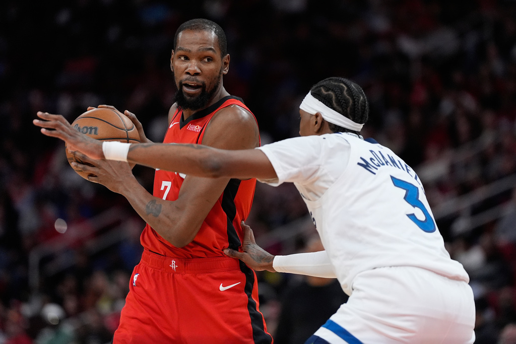 Minnesota Timberwolves forward Jaden McDaniels (3) defends against Houston Rockets forward Kevin Durant (7) during the first half of an NBA basketball game in Houston, Friday, Jan. 16, 2026. (AP Photo/Ashley Landis)
