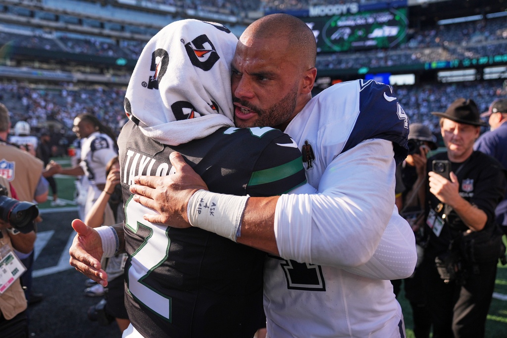Dallas Cowboys' Dak Prescott hugs New York Jets' Tyrod Taylor after an NFL football game Sunday, Oct. 5, 2025, in East Rutherford, N.J. (AP Photo/Seth Wenig)