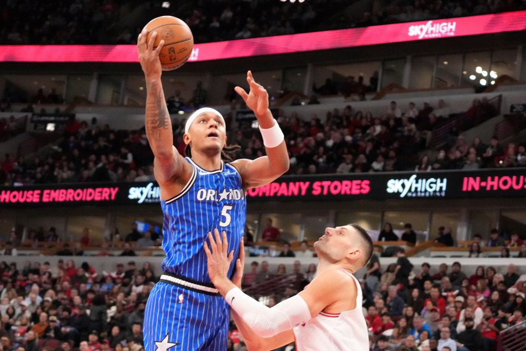 Orlando Magic forward Paolo Banchero, left, shoots over Chicago Bulls center Nikola Vucevic during the first half of an NBA basketball game, Friday, Jan. 2, 2026, in Chicago. (AP Photo/David Banks)