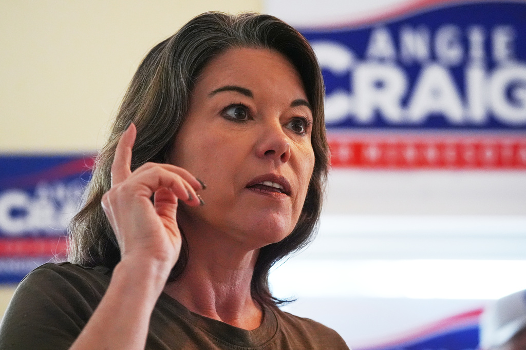 U.S. Rep. Angie Craig, D-Minn., a candidate for U.S Senate, speaks to constituents during a door-knocking event Saturday, July 25, 2026, in Minneapolis. (AP Photo/Ellen Schmidt)
