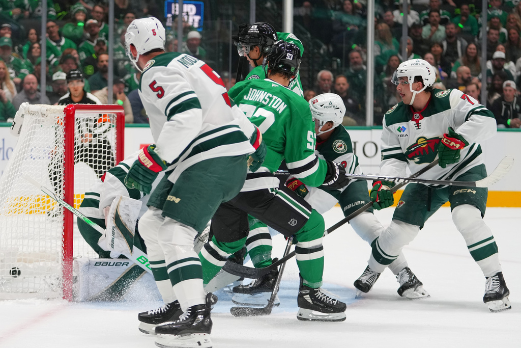 A shot by Dallas Stars center Wyatt Johnston (53) enters the net of Minnesota Wild goaltender Filip Gustavsson for a goal during the first period of an NHL hockey game Tuesday, Oct. 14, 2025, in Dallas. (AP Photo/Julio Cortez)
