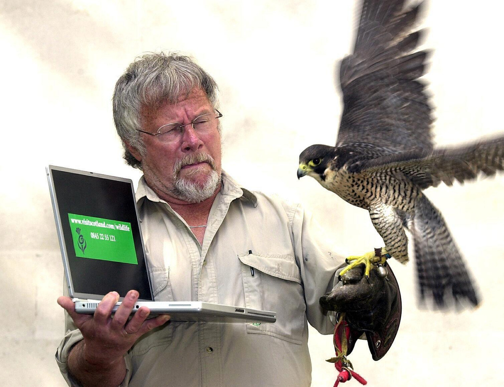 FILE - Bill Oddie launches the Visit Scotland new website (www.visitscotland.com/wildlife) with Tam the Peregrine falcon at Visitscotland's London office, May 6, 2004. (Michael Stephens/PA via AP, File)