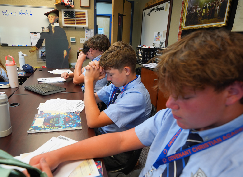 Students pray during a U.S. history class at Covenant Christian Academy in Colleyville, Texas, Wednesday, Aug. 12, 2026. (AP Photo/LM Otero)