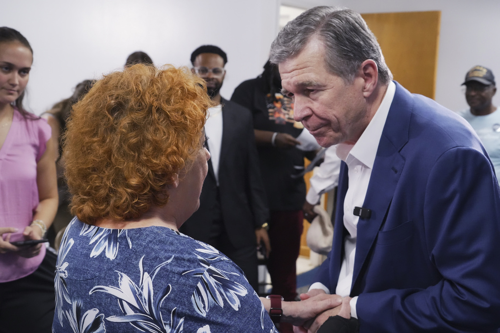 Former Democratic Gov. Roy Cooper, who is running for U.S. Senate, holds hands with a woman following a campaign event at St. James African Methodist Episcopal Church in Goldsboro, N.C., on Thursday, Sept. 10, 2026. (AP Photo/Allen G. Breed)