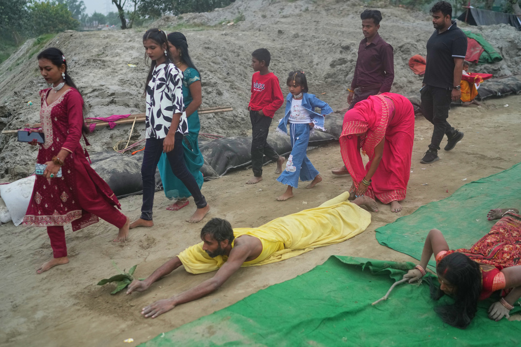 A devotee prostrates and performs rituals on his way to the River Yamuna during the Chhath festival, which is celebrated for the well-being and prosperity of one's family, in New Delhi, India, Monday, Oct. 27, 2025. (AP Photo/Manish Swarup)