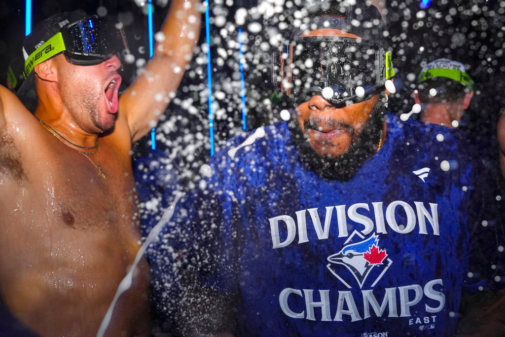 Toronto Blue Jays first baseman Vladimir Guerrero Jr. (right) George Springer join teammates as they celebrate winning the American League East Division title following MLB baseball action against the Tampa Bay Rays, in Toronto, Sunday, Sept. 28, 2025. (Chris Young/The Canadian Press via AP)