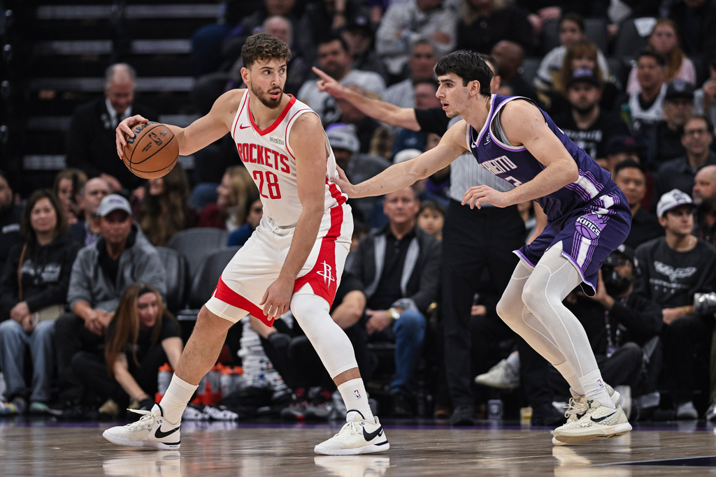 Houston Rockets center Alperen Sengun (28) dribbles against Sacramento Kings center Maxime Raynaud, right, during the first half an NBA basketball game, Sunday, Dec. 21, 2025, in Sacramento, Calif. (AP Photo/Justine Willard)