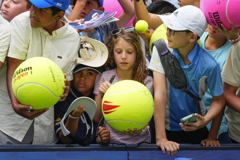 Tennis fans wait for autographs from Jannik Sinner, of Italy, during the first round of the U.S. Open tennis championships, Tuesday, Aug. 26, 2025, in New York. (AP Photo/Yuki Iwamura)