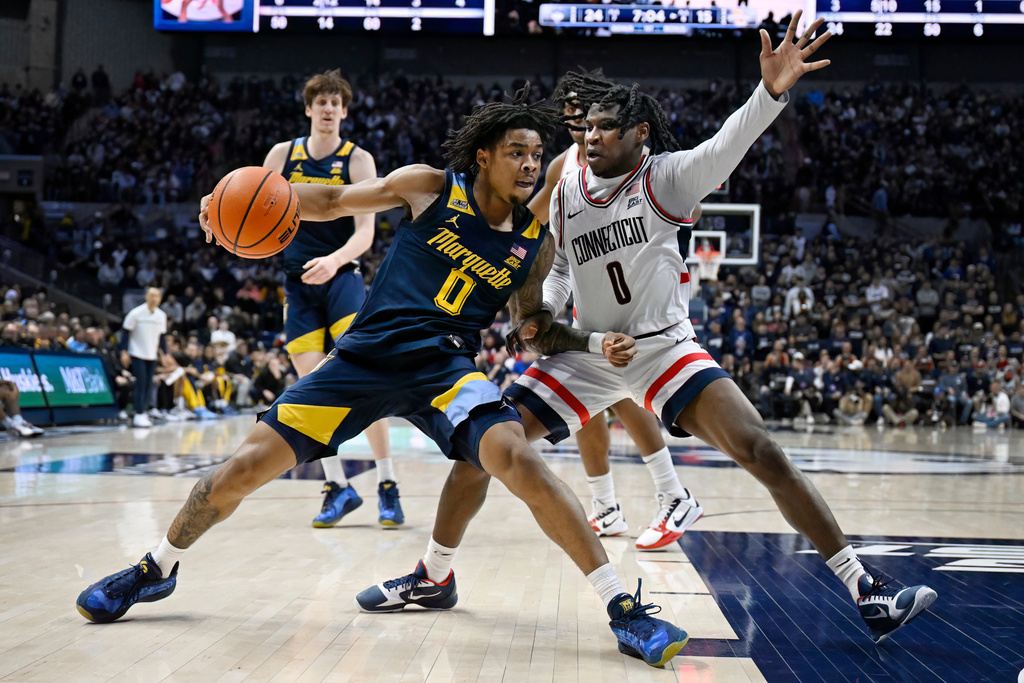 Marquette guard Nigel James Jr., front left, drives to the basket as UConn guard Malachi Smith, right, defends in the first half of an NCAA college basketball game, Sunday, Jan. 4, 2026, in Storrs, Conn. (AP Photo/Jessica Hill)