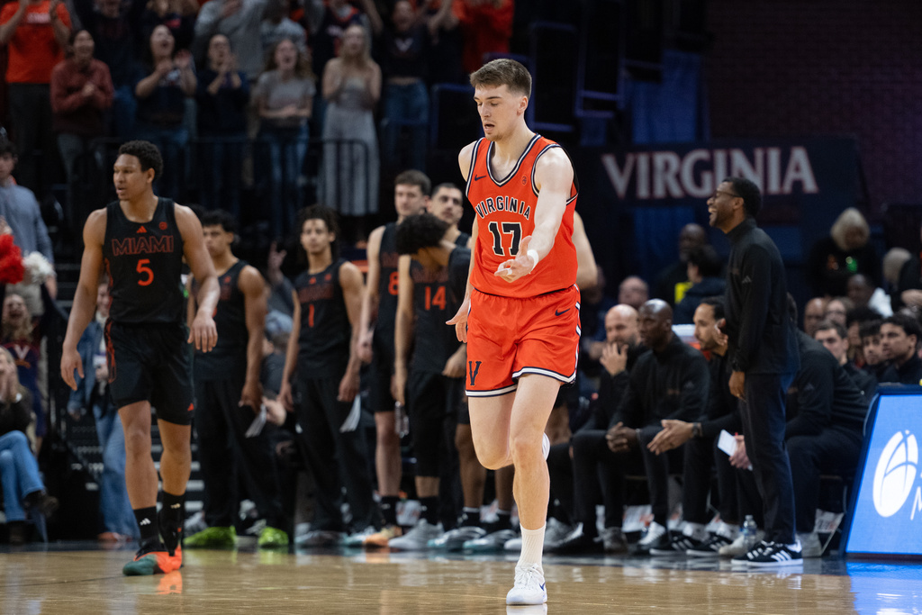 Virginia center Johann Grünloh (17) celebrates scoring 3-point shot against Miami during the first half of an NCAA college basketball game, Saturday, Feb. 21, 2026, in Charlottesville, Va. (AP Photo/Robert Simmons)