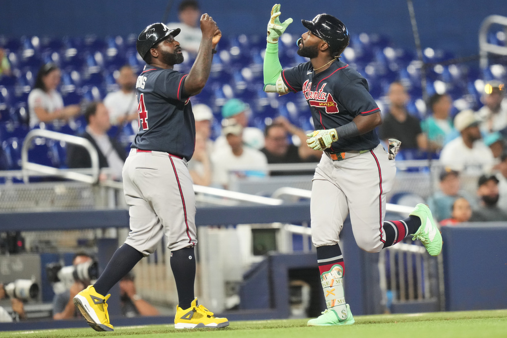 Atlanta Braves' Michael Harris II, right, high-fives third base coach Tommy Watkins, left, after hitting a solo home run during the sixth inning of a baseball game against the Miami Marlins, Tuesday, May 19, 2026, in Miami. (AP Photo/Lynne Sladky)