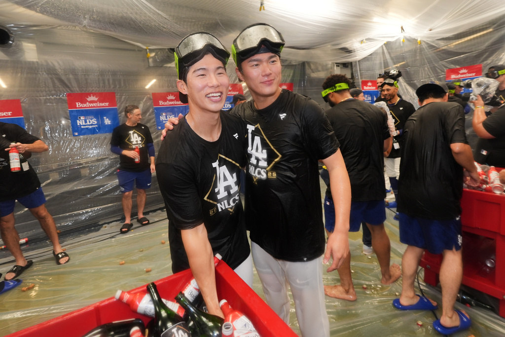 Los Angeles Dodgers' Hyeseong Kim, left, and Yoshinobu Yamamoto embrace after a win over the Philadelphia Phillies in Game 4 of baseball's National League Division Series Thursday, Oct. 9, 2025, in Los Angeles. (AP Photo/Jae C. Hong)