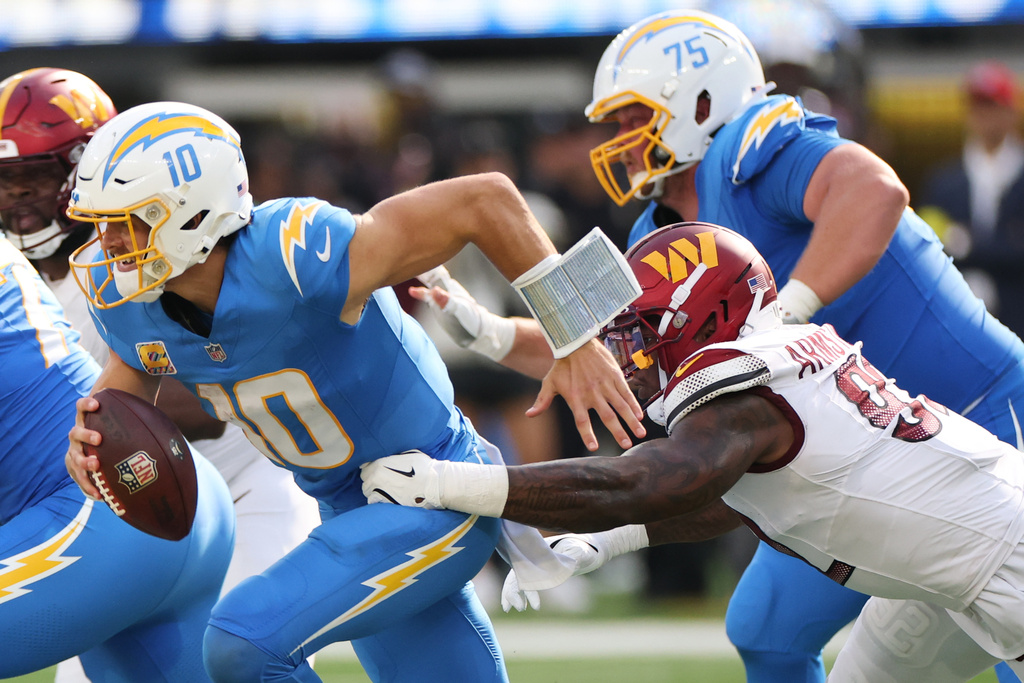 Los Angeles Chargers quarterback Justin Herbert (10) is sacked by Washington Commanders defensive end Dorance Armstrong during the second half of an NFL football game Sunday, Oct. 5, 2025, in Inglewood, Calif. (AP Photo/Eric Thayer)