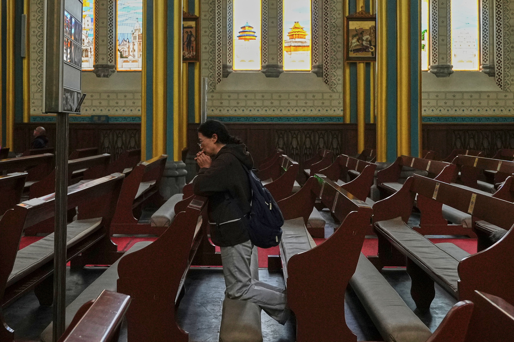 FILE - A person prays at the Xishiku Catholic Church, in Beijing, May 9, 2025. (AP Photo/Andy Wong, File)